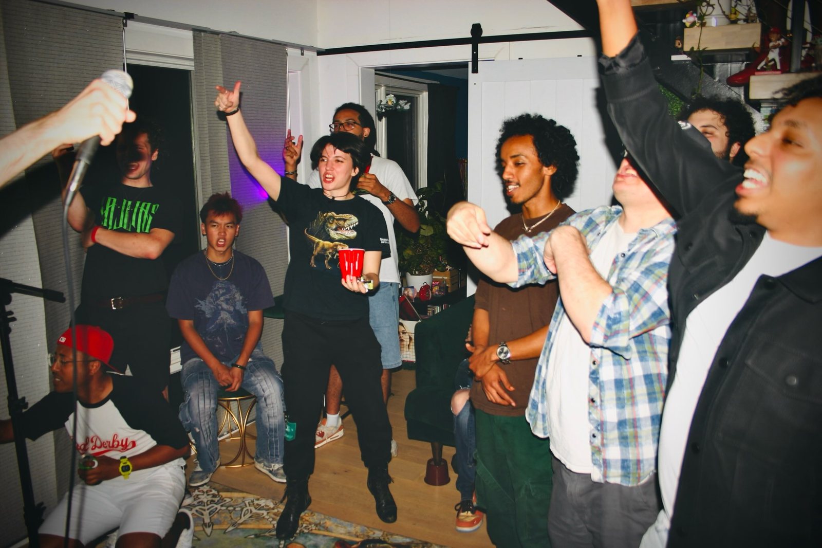 A crowd cheering with arms raised during a performance.